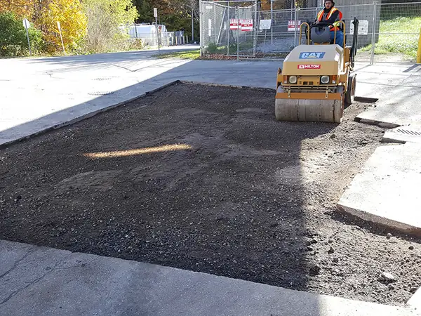 Fresh asphalt at a plaza entrance next to new concrete