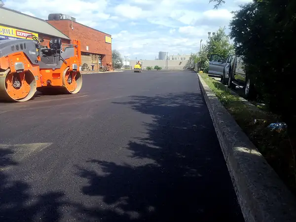 Roller compacting a newly paved road