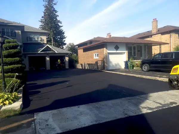 Long new driveway beside a house and garage